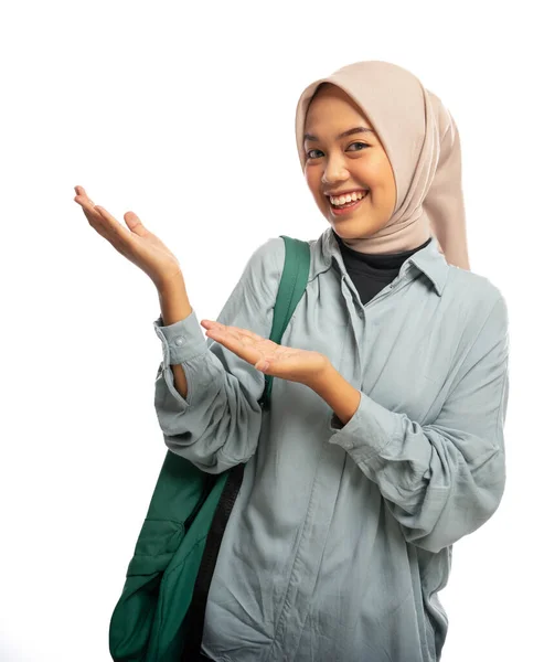 Leende Muslimsk Kvinnlig Universitetsstudent Som Erbjuder Något Bredvid Isolerad Bakgrund — Stockfoto