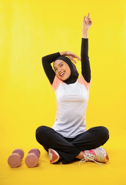 Relajado Asiático Musulmán Mujer Usando Sportswear Sienta Haciendo Estiramiento Amarillo —  Fotos de Stock