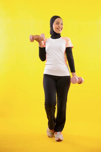 Muslimah Femenina Asiática Ejercitándose Con Mancuernas Sobre Fondo Amarillo —  Fotos de Stock