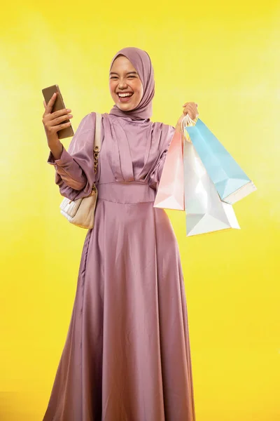 Glad Feminin Muslimah Stående Med Mobiltelefon Och Papper Shoppingväska Gul — Stockfoto