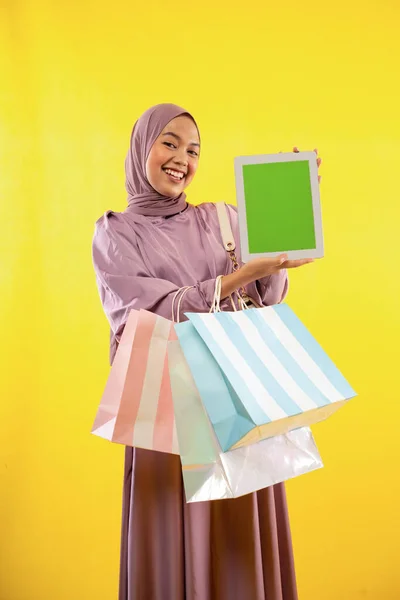 Sarı Arka Planda Ped Ekranı Gösteren Pembe Tesettürlü Müslüman Kadın — Stok fotoğraf