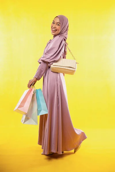 Asiatisk Kvinna Hijab Klänning Skrattar Med Shoppingväska Gul Bakgrund — Stockfoto