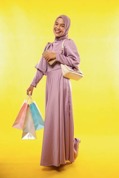 漂亮的亚洲女人 购物时穿着带头巾的彩色衣服 黄底孤零零的 — 图库照片