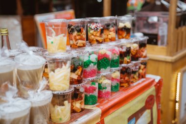Sokak satıcılarından alınmış plastik bardakta renkli tatlı içecekler.