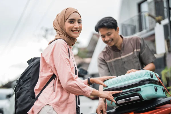 快乐的亚洲穆斯林夫妇在返回故土途中骑摩托车旅行时 把他的手提箱收拾好 — 图库照片