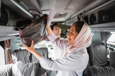 Bayramlarda seyahat ederken başörtülü kadın çantasını otobüs durağına koyar.