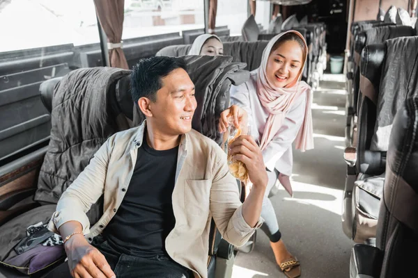 在乘车旅行中与他人分享零食的穆斯林乘客 — 图库照片