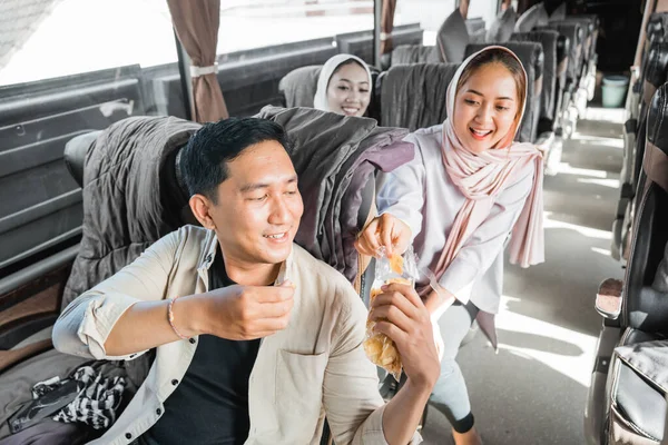 在乘车旅行中与他人分享零食的穆斯林乘客 — 图库照片