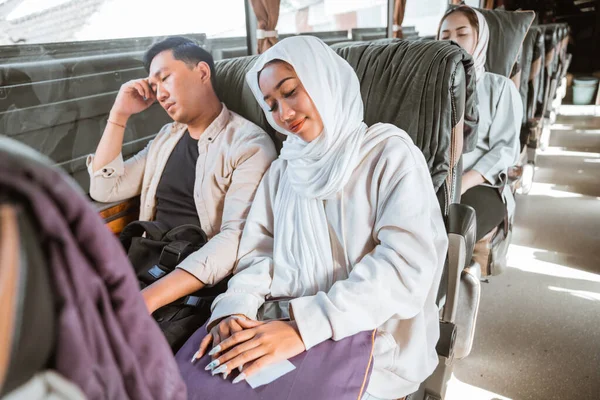Young man and woman take a nap during road trip on the bus