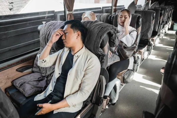 Young man and woman feeling tired and sick during road trip on the bus
