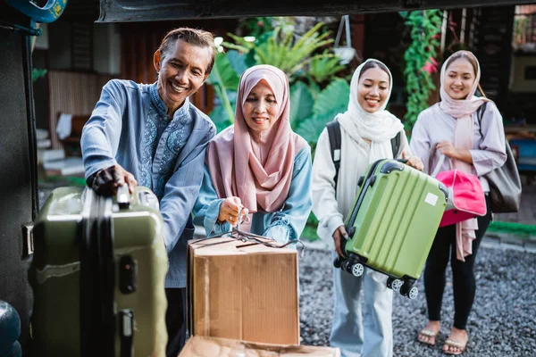 両親がバスで旅行している幸せなアジア系ムスリムの乗客です 家族の肖像はスーツケースをバスのトランクに入れています — ストック写真