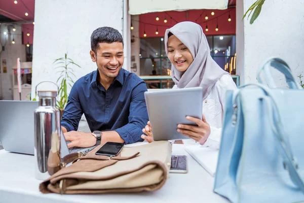 同僚のスペースで一緒にノートパソコンを使って働く幸せな男性とイスラム教徒の女性 — ストック写真