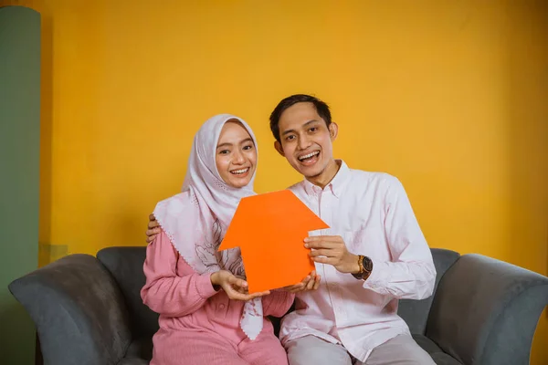 Feliz Asiático Musulmán Pareja Mostrando Papel Casa Formas Mientras Sentado —  Fotos de Stock