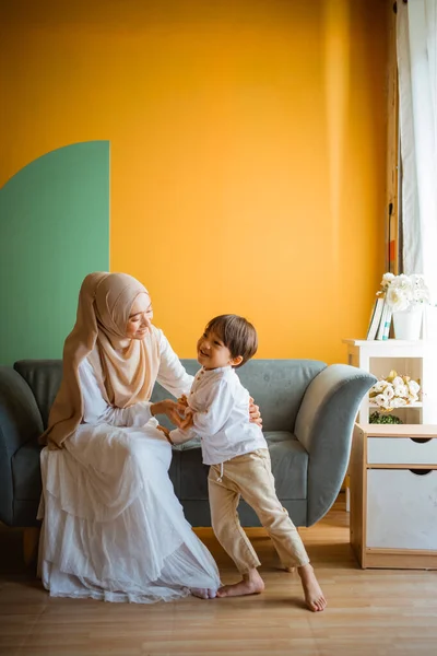 アジアのイスラム教徒のお母さん遊びともに小さな男の子でソファに座ってリビングルーム — ストック写真