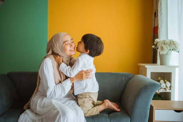 Ibu Muslim Asia Memeluk Dan Mencium Anak Duduk Sofa Ruang — Stok Foto