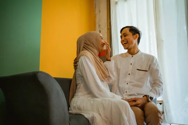 ロマンチックなアジアの夫と妻座って冗談でザリビングルームのソファ — ストック写真