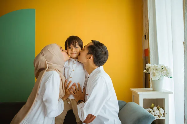 Ibu Muslim Asia Ayah Memeluk Dan Mencium Anak Duduk Sofa — Stok Foto
