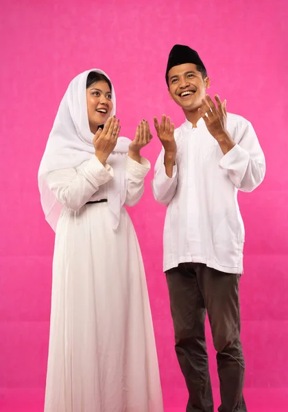 アジア系イスラム教徒のカップルの肖像画はピンクの背景に手のジェスチャーで立っている — ストック写真