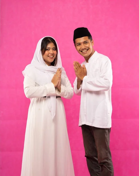 亚洲男性和女性穿着粉色背景穆斯林服装的肖像 — 图库照片