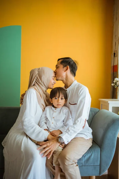 아버지는 사랑의 형태로 어머니들의 이마에 아들을 무릎에 앉히고 Eid 축하하며 — 스톡 사진