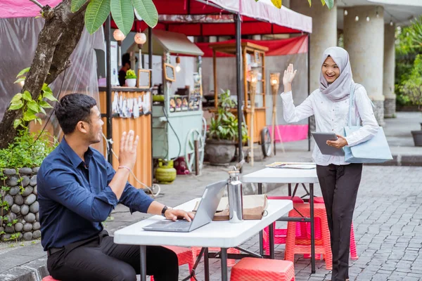 亚洲男女商业伙伴在咖啡店见面时互相挥手致意 — 图库照片