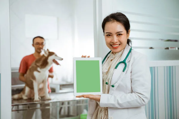 Egy Gyönyörű Állatorvos Támaszkodik Ajtó Mutatja Tabletta Kezét Barna Szibériai — Stock Fotó