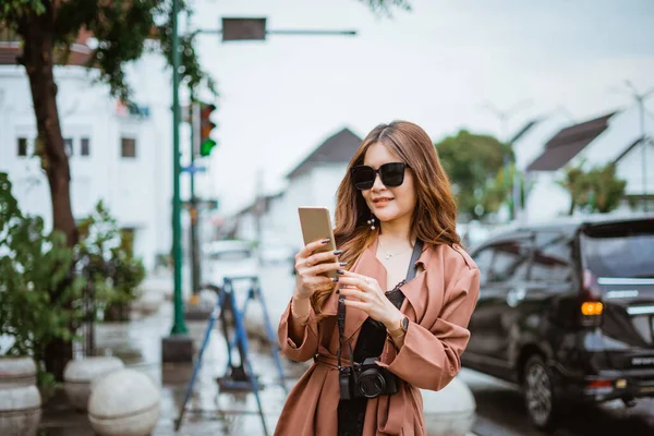 Női Utazó Szemüveggel Nézi Telefont Miközben Áll Járdán — Stock Fotó