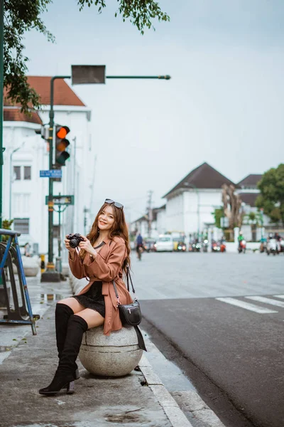 Fêmea Viajante Segurando Câmera Enquanto Sentado Assento Pedra Calçada Com — Fotografia de Stock