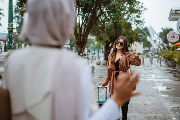 Női Utazó Szemüvegben Integet Barátjának Hidzsábbal Akivel Járdán Sétálva Találkozott — Stock Fotó