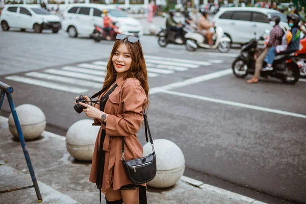 Female Traveller Glasses Her Head Holding Camera While Standing Sidewalk — Stock Photo, Image