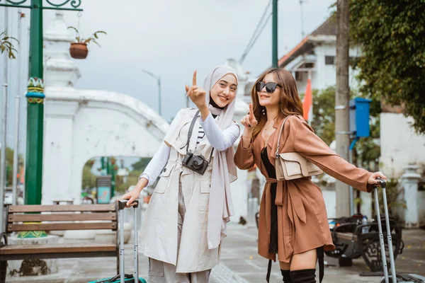 Två Kvinnliga Resenärer Tar Med Sig Sina Badbyxor Och Pekar — Stockfoto