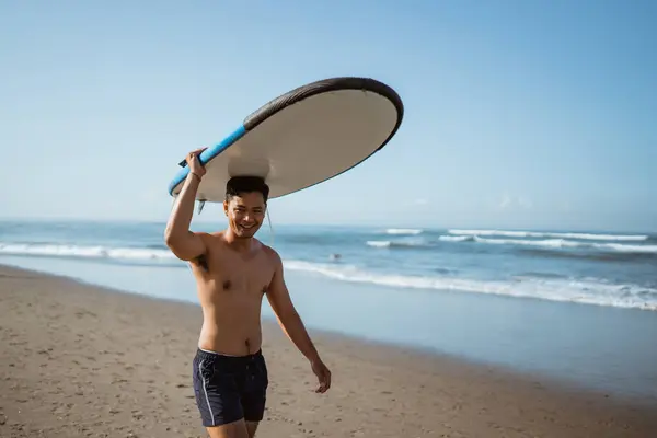 英俊的亚洲男人 头上带着冲浪板 沿着海滩散步 享受假期 — 图库照片