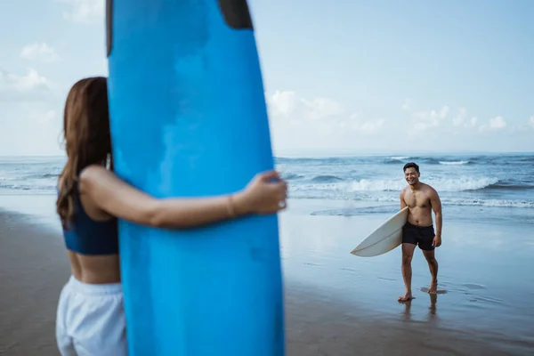 在海滩上练习带冲浪板后 男冲浪者遇见了女性朋友 — 图库照片