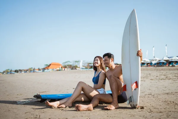 两个冲浪者坐在沙滩上的冲浪板上 — 图库照片