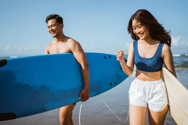 穿着泳衣的男子和妇女在训练前携带冲浪板 健康的生活方式概念 — 图库照片