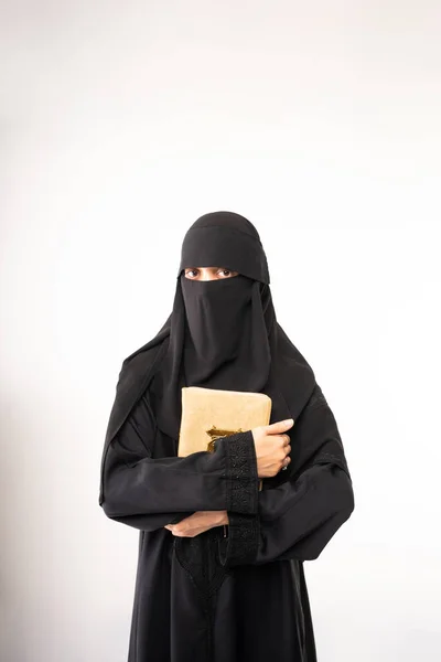 身穿黑色头巾或Niqab 身穿长裙的穆斯林妇女站在那里 手里拿着四冠冕 望着摄像机 — 图库照片