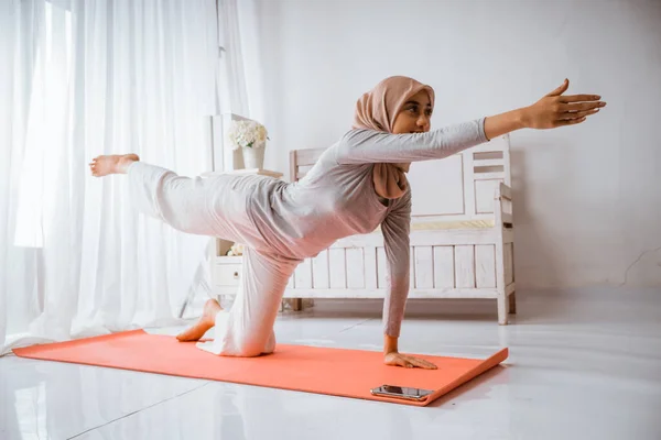 亚洲穆斯林女教官头戴头巾 做瑜伽普拉提 在房间里的橙色床垫上摆出辅导姿势 — 图库照片