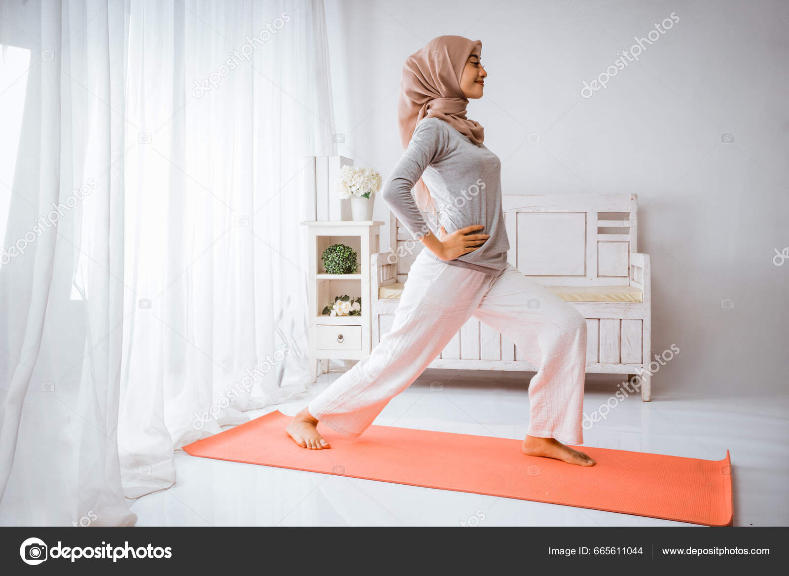 Una mujer joven con un traje de entrenamiento hijab se pone en