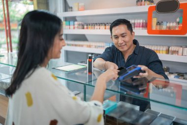 Vape mağazasındaki kredi kartını kullanan kadın müşteriler.
