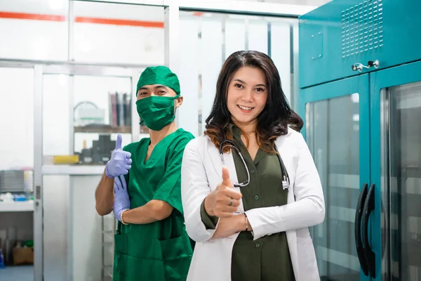 Dva Lékaři Bílých Zelených Uniformách Stojí Palci Nahoru Nemocnici — Stock fotografie
