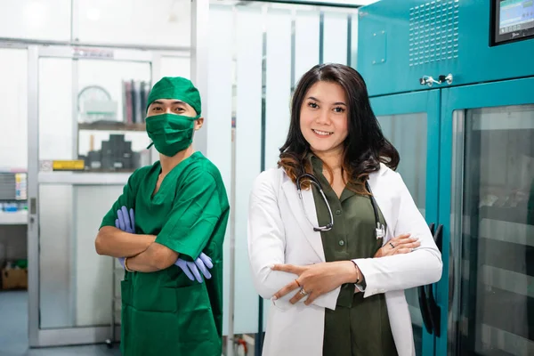Dos Médicos Vestidos Con Uniformes Blancos Verdes Están Pie Con —  Fotos de Stock