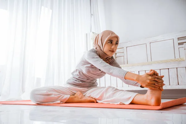 亚洲穆斯林女教官头戴头巾 做瑜伽普拉提 在房间里的橙色床垫上摆出辅导姿势 — 图库照片
