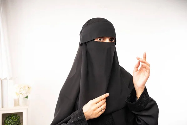 穆斯林妇女 头戴黑色头巾或面纱 身穿长裙 摆出姿势 举起左手 — 图库照片