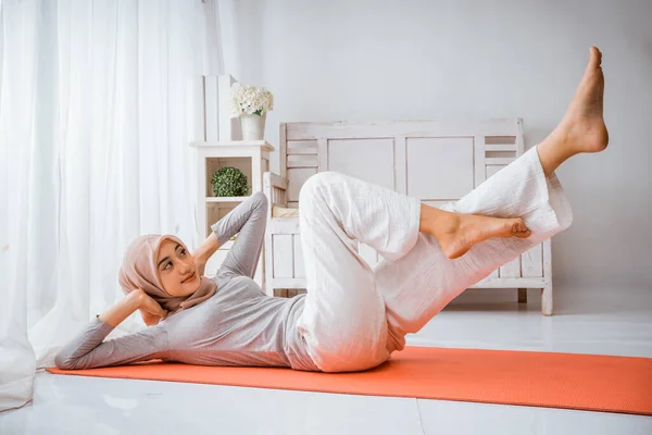 在做瑜伽或普拉提运动前 穿着头巾T恤衫的穆斯林妇女在房间的床垫上摆姿势 — 图库照片