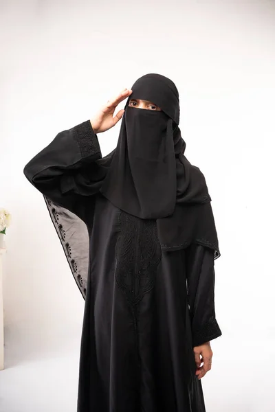 身穿黑色头巾或面纱的穆斯林妇女和站在房间里敬礼的长裙 — 图库照片