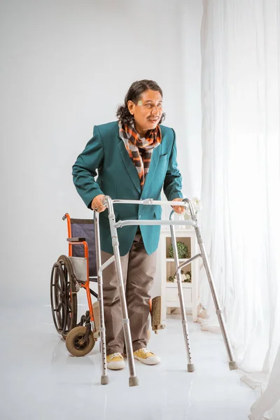 亚洲老人笑着站在轮椅前 试图与行尸走肉快乐地在养老院里散步 — 图库照片