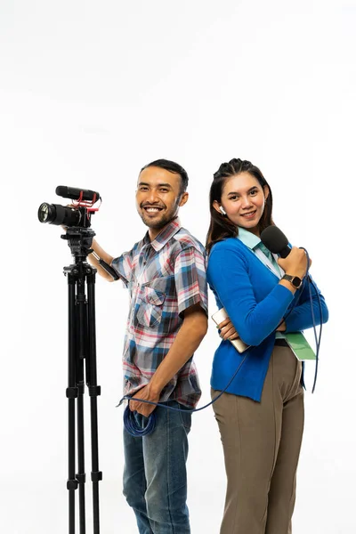青いシャツを着た女性記者とカメラを持ったカメラマンの隣にマイクを持った青いカーディガン — ストック写真