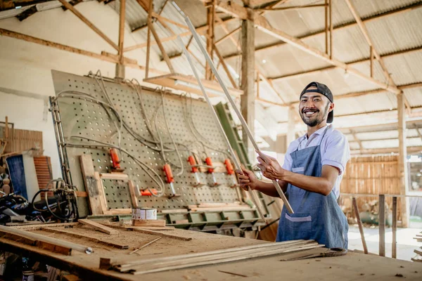 Carpintero Macho Sonríe Cámara Mientras Sostiene Material Madera Antes Trabajar —  Fotos de Stock