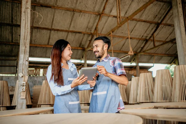 木工芸店で一緒にタブレットを操作しながら アジアの起業家のカップルのチャット — ストック写真