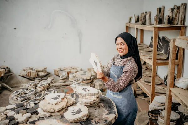 アジア系イスラム教徒のビジネスマンの側の景色石工工房の部屋で石切りの工芸品を持っているおもちゃの笑顔で — ストック写真